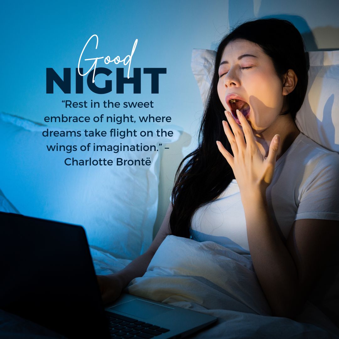 A woman yawning while working on her laptop in bed at night, with an inspirational good night message and a quote by Charlotte Brontë about dreams and imagination illuminated by the screen's glow.