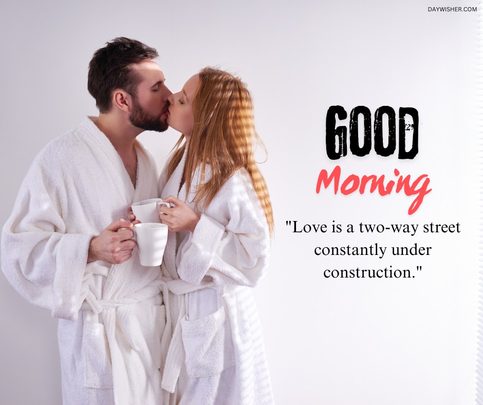 A loving couple sharing a morning kiss in white robes, holding coffee mugs, with the text "Good Morning" and the quote "Love is a two-way street constantly under construction." Perfect for expressing romantic and cozy morning vibes.