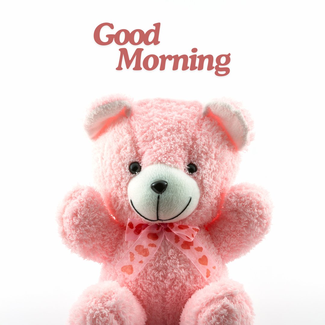 A cute good morning teddy bear in pink with a heart-patterned bow, sitting against a white background. The image features the text "Good Morning" in a warm, welcoming font.