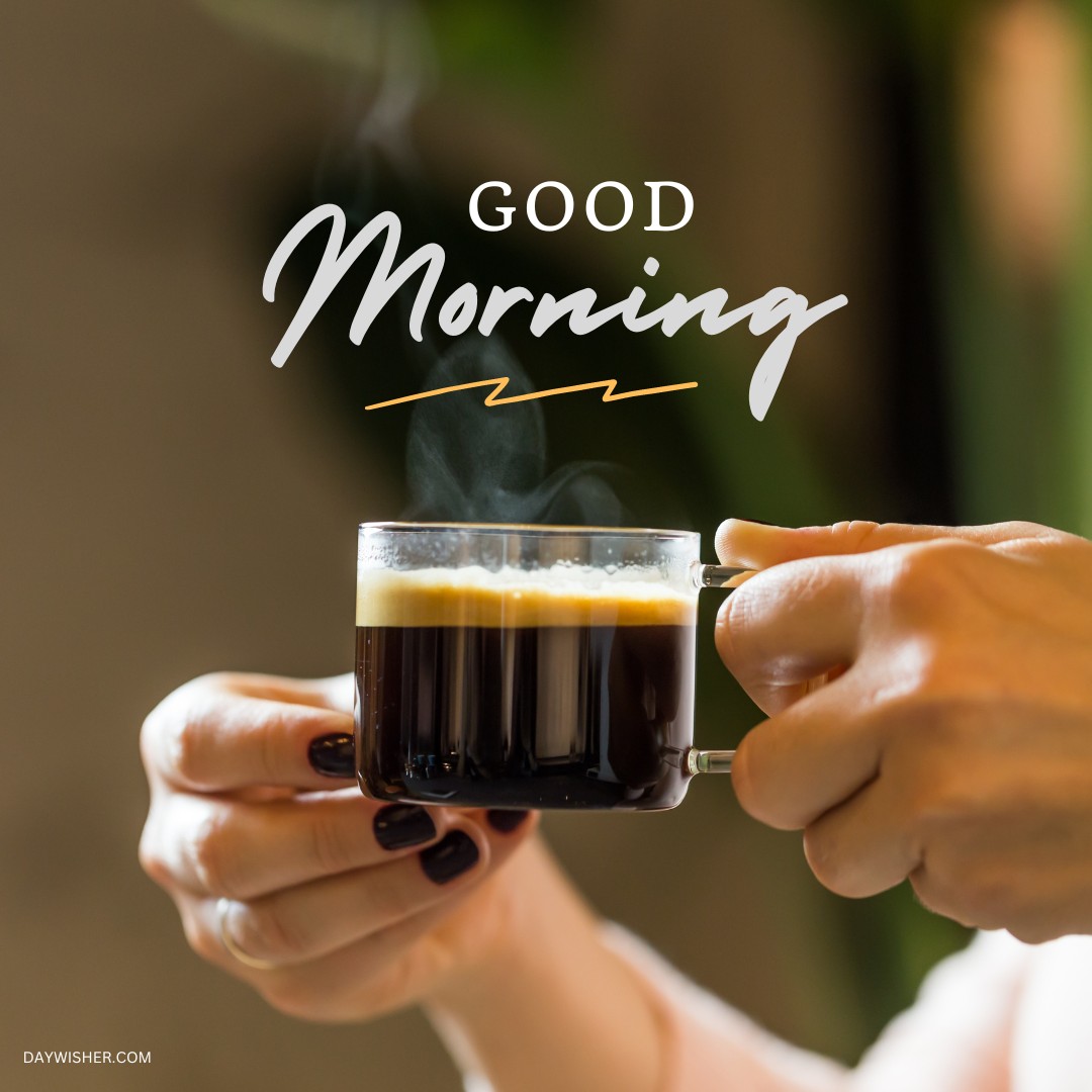 A close-up of hands holding a clear espresso cup filled with rich coffee, steam rising gently above it against a blurred natural backdrop. The elegant "Good Morning" script enhances the image, perfectly capturing the essence of a peaceful morning. Ideal for those seeking good morning coffee images that convey the warmth and comfort of starting the day with a fresh brew.