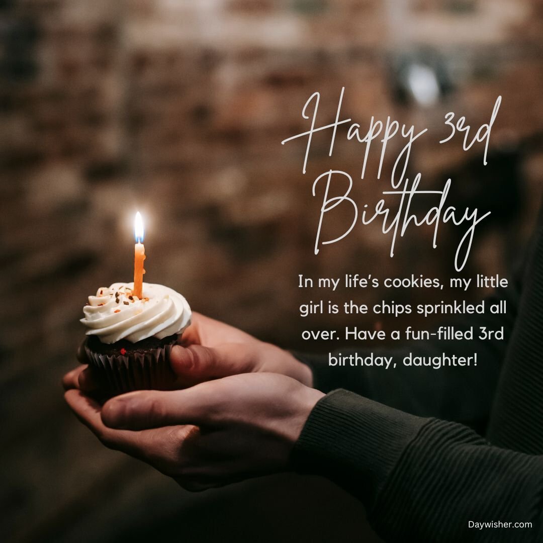 A person holding a cupcake with a lit candle, featuring an "adorable happy 3rd birthday" message for a daughter, expressed on a cozy background.