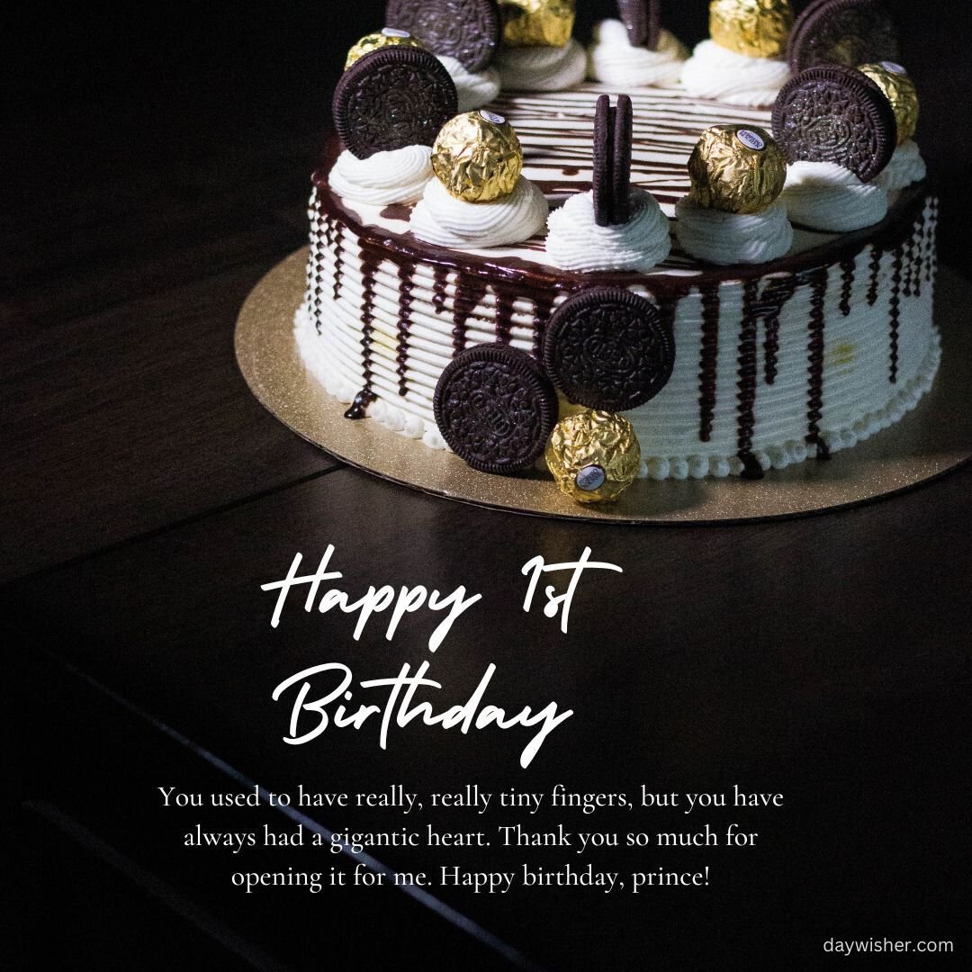 A birthday cake with "happy 1st birthday" written on it, decorated with striped chocolate pieces and cookies, presented on a wooden table in a dim ambiance.