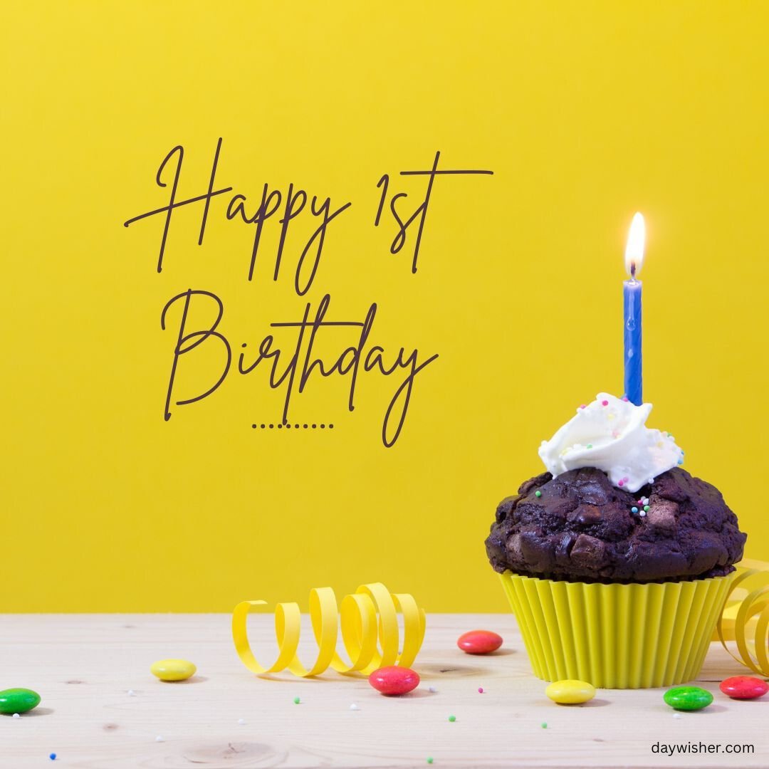 A chocolate muffin topped with white icing and a lit blue candle, surrounded by colorful candies on a wooden table, against a yellow background with "happy 1st birthday images" written in script.