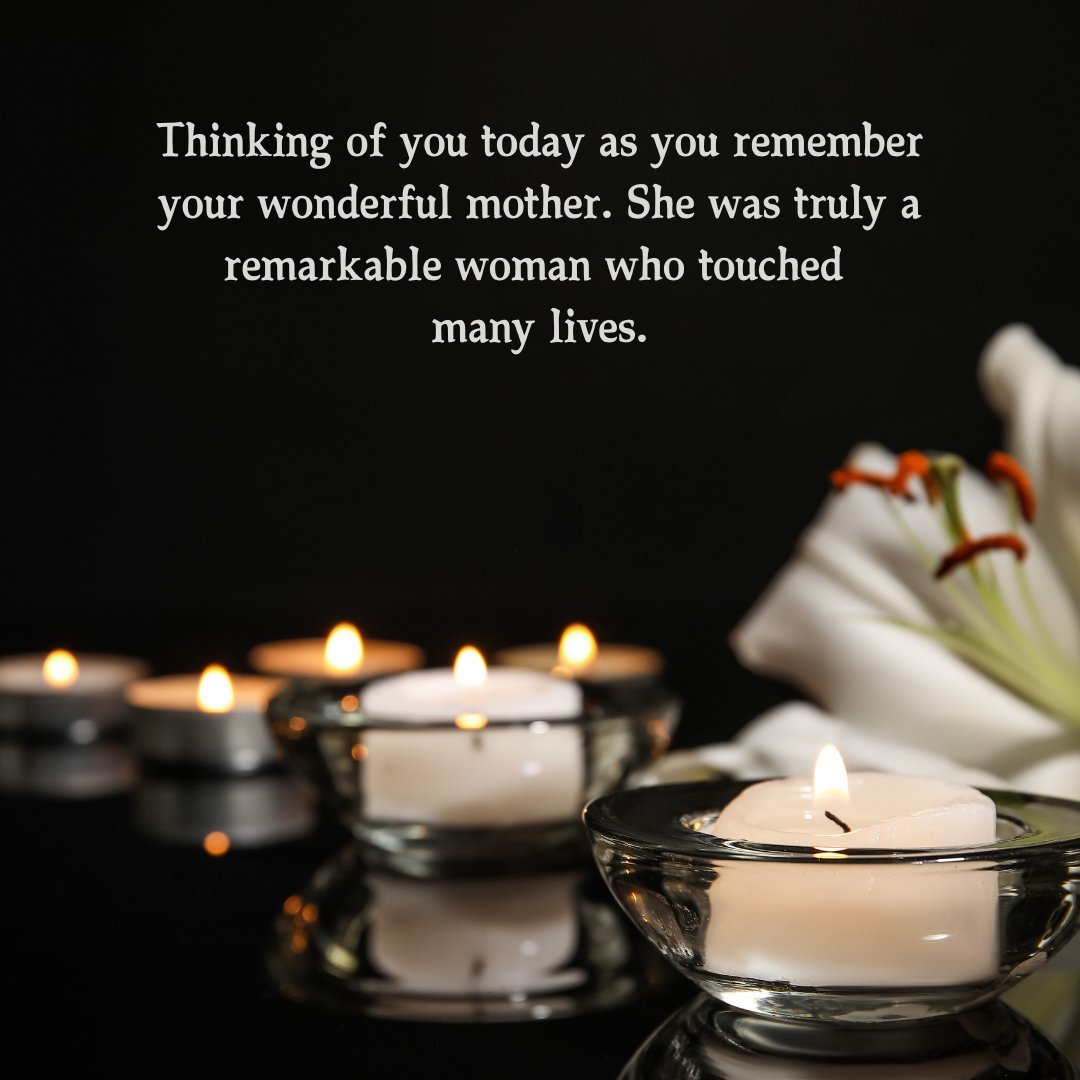 Several lit candles in glass holders and a white lily on a reflective dark surface, accompanied by a thoughtful message for a friend's mother on her death anniversary.